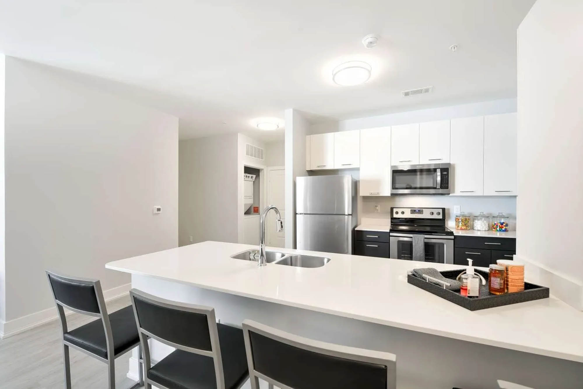 Bright and spacious kitchen with white cabinets a large island and stainless steel appliances