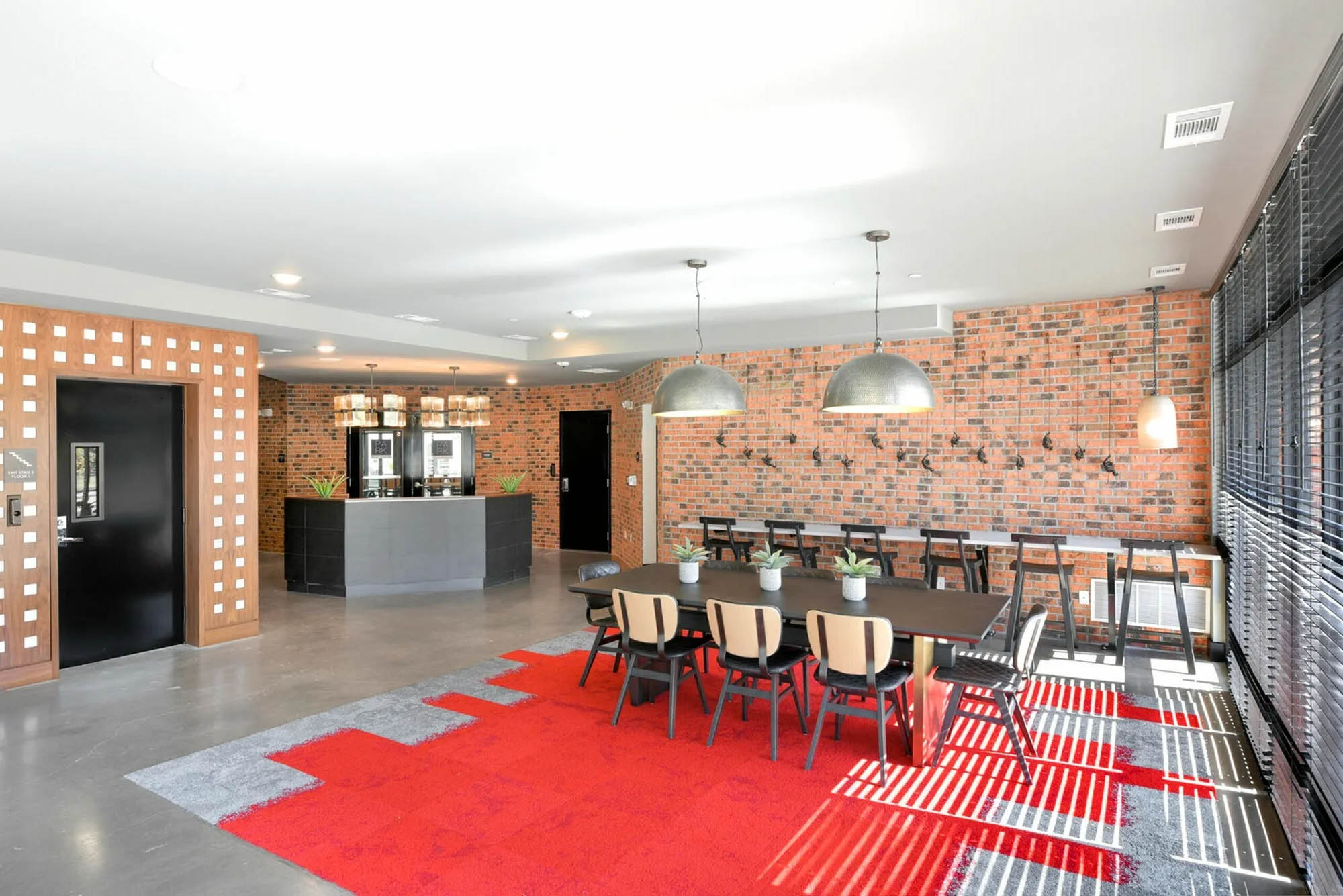 Community seating in common space with cafe and bright rug