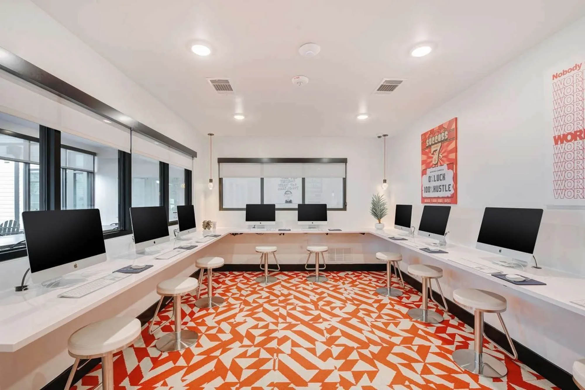 Computer room with Mac computers plenty of seating and abstract orange rug
