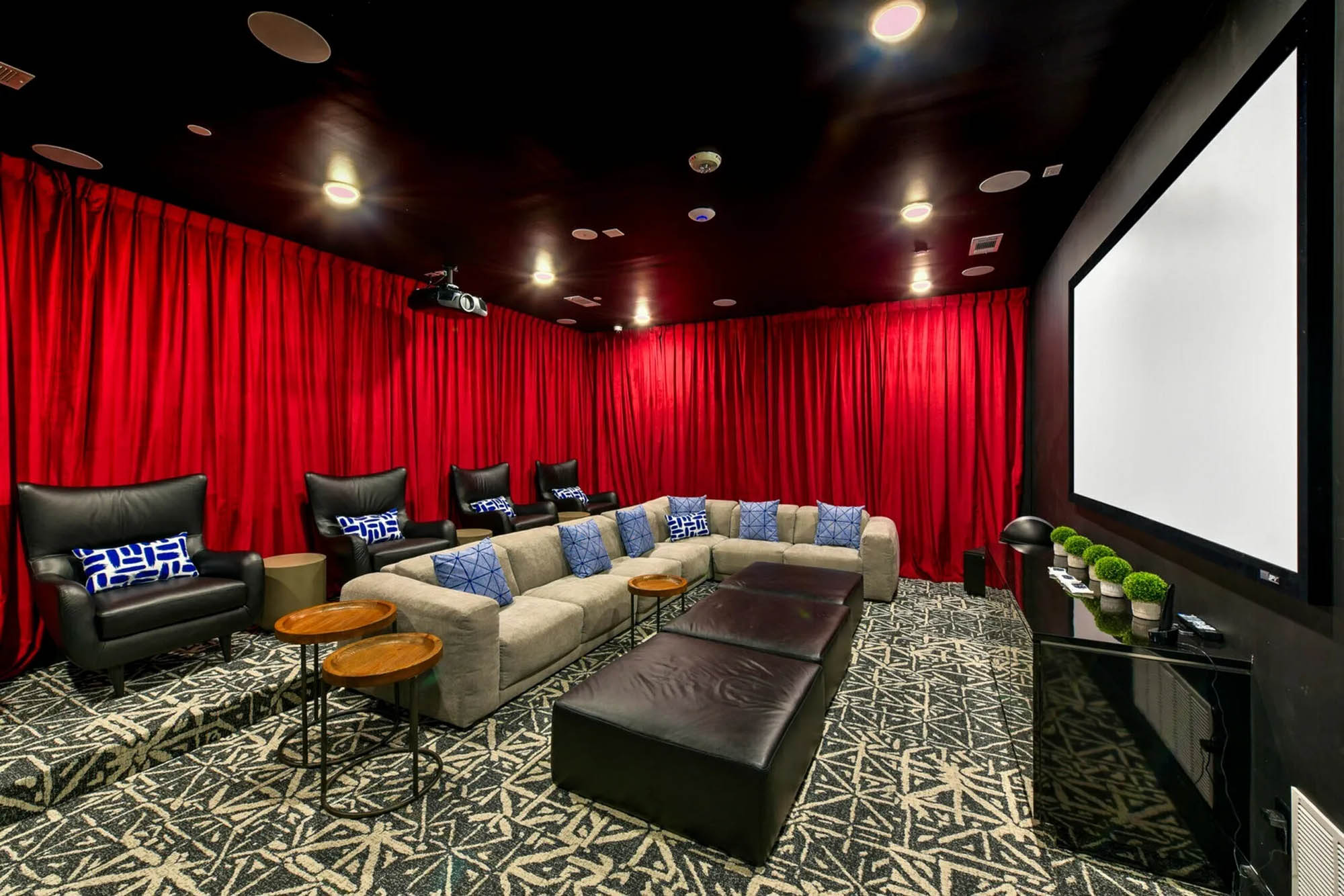 Mini movie theater with reclinters couches and red velvet curtains